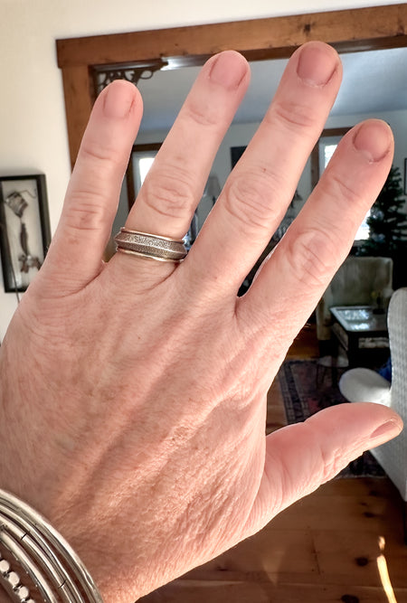 silver and gold textured ring on hand