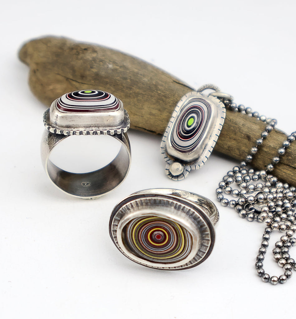Sterling silver rings and pendants with fordite cabochons set in a bezel
