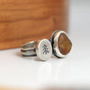 double sided ring with a beach stone and small silver disc with stamped tree