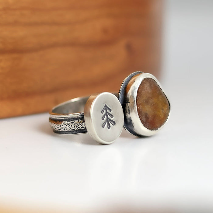 double sided ring with a beach stone and small silver disc with stamped tree