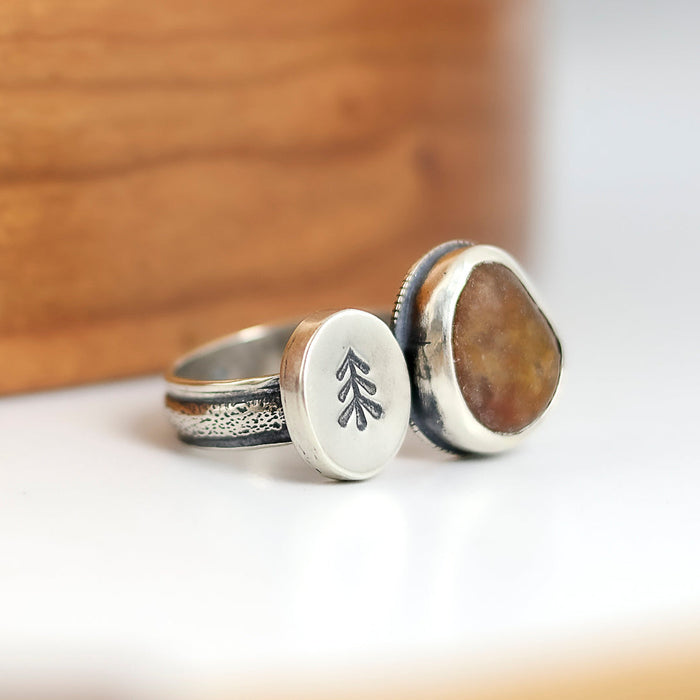 Handmade double sided sterling silver ring with reddish brown beach stone and hand stamped tree
