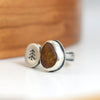 double sided ring with a beach stone and small silver disc with stamped tree