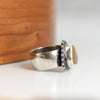 Silver ring  on a white surface with wooden background