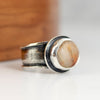 Silver ring with a beach stone  on a wooden surface