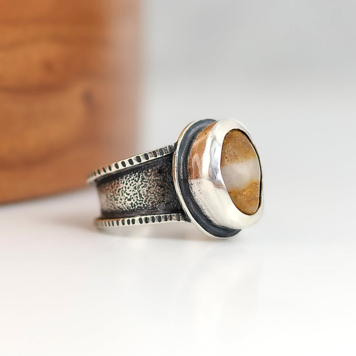 Silver ring with a natural  beach stone on a light background