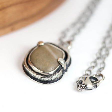 Silver necklace with a pendant on a white surface