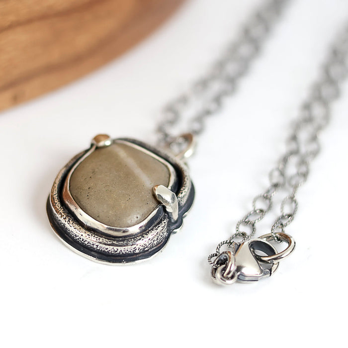 Silver necklace with a pendant on a white background