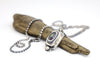 Necklace with a pendant on a piece of driftwood against a white background