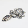 Silver pendant with a chain on a white background