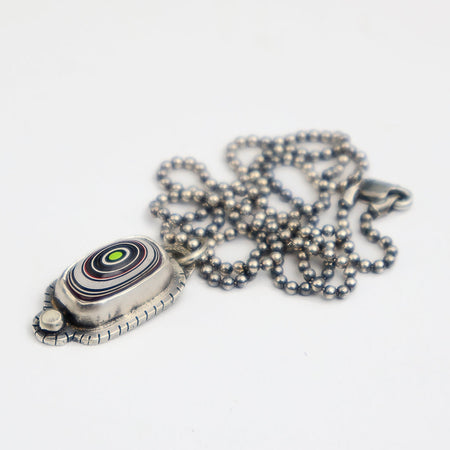 Silver pendant with a chain on a white background