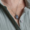 Necklace with a pendant worn by a person wearing a light green shirt.