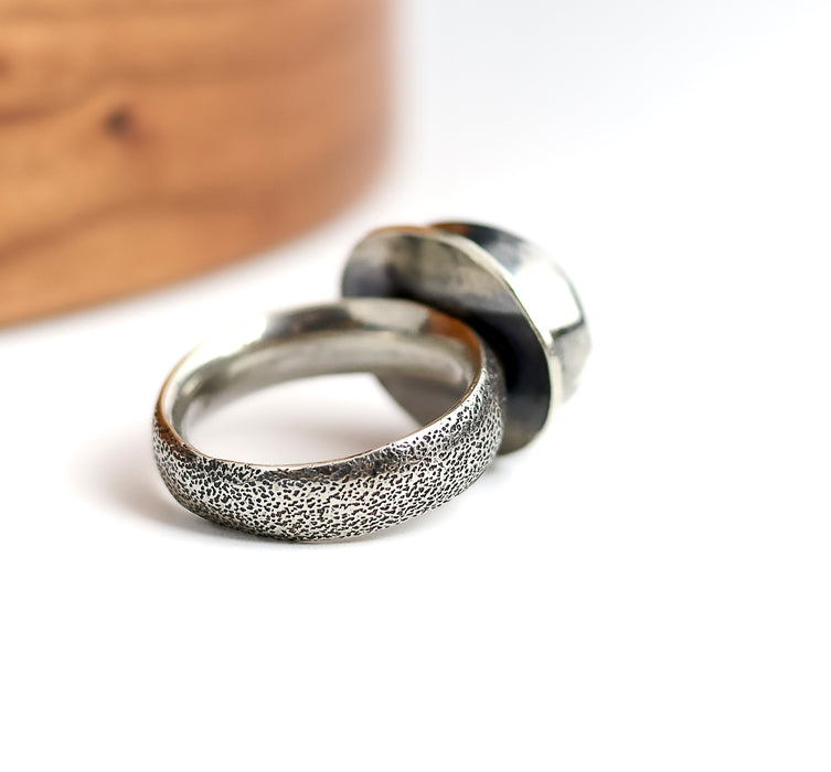 Silver ring with textured surface on a white background