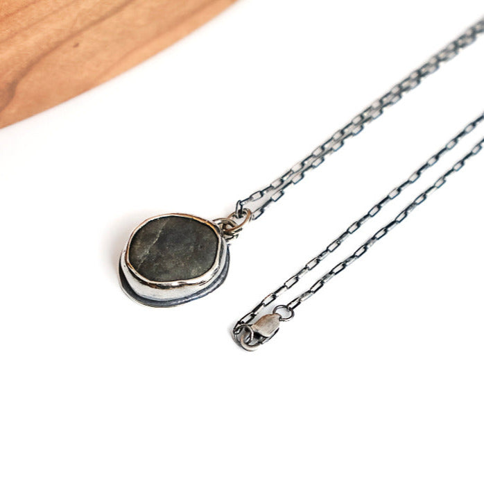 Necklace with a beach stone pendant on a white surface