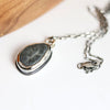 Necklace with a pendant featuring a natural stone on a white background