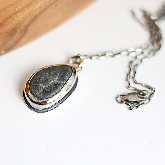 Necklace with a pendant featuring a natural stone on a white background