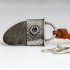 beach stone pendant with a silver textured end cap on a brown suede cord