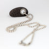 beach stone pendant on a silver chain on a white background