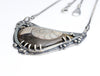 Silver necklace with a pendant featuring a ammonite fossil  on a white background