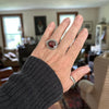 Handmade sterling silver ring with horizontal rose cut hessonite garnet worn on a hand, dot textured bezel border and half round comfort fit band, size 7