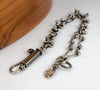 Sterling silver chain bracelet with a citrine in a tube setting, photographed on a white surface with a wooden edge in the corner.