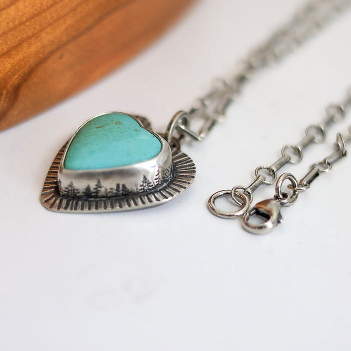 Necklace with a heart-shaped turquoise pendant on a white surface