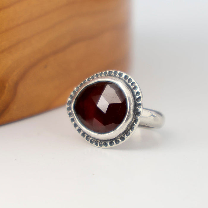 Handmade sterling silver ring with horizontal rose cut hessonite garnet, dot textured bezel border and half round comfort fit band, size 7