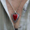 Necklace with a red heart pendant worn by a person