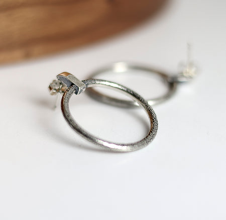 Silver hoop earrings on a light background