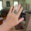 Sterling silver ring  worn on a hand with round Emerald Valley turquoise from Nevada in square bezel setting, triple textured band, handmade by LjB Jewelry