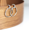 Silver hoop earrings on a wooden surface