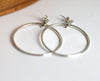Silver hoop earrings on a white surface