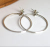 Silver hoop earrings on a white surface