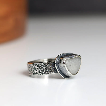 Silver ring with textured band and heart-shaped beach stone
