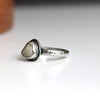 Silver ring with a white beach stone on a white background