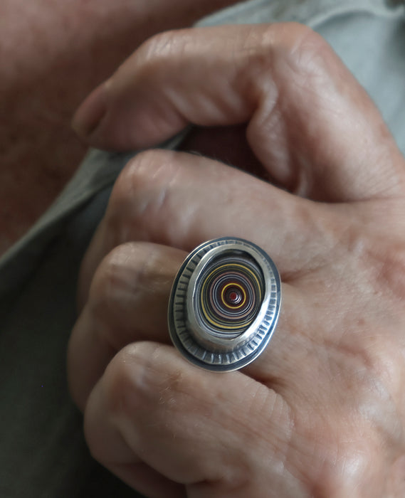 silver fordite ring worn on a hand