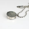 the back view of an amethyst pendant on an oval silver bead chain