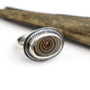 Silver ring with a circular design on a white background