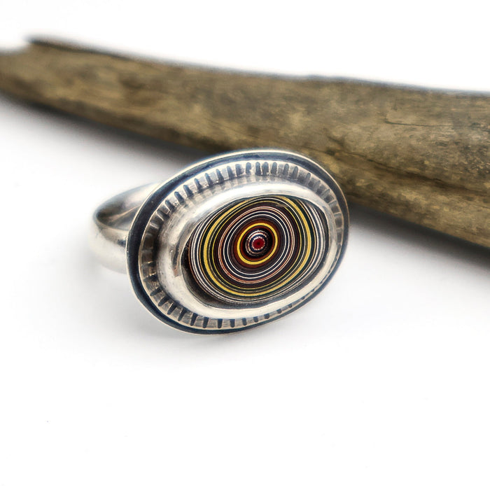 Silver ring with a circular design on a white background