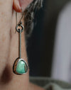 Sterling silver dangle earrings worn on a ear with green turquoise stones and hand textured square wire, handmade by LjB Jewelry, 