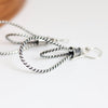 Silver hoop earrings on a white surface with a wooden background