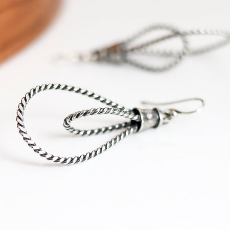 Silver twisted hoop earrings on a white background