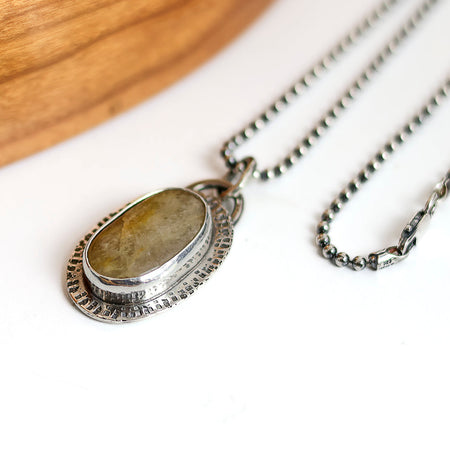 Necklace with a stone pendant on a white surface