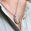 Necklace with a pendant worn by a person, focusing on the jewelry.