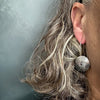 sterling silver textured dangle earrings on ear